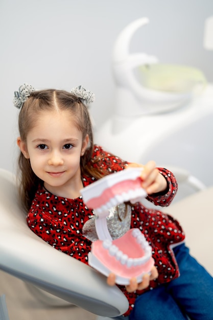 Kid spelen met plastic stand tanden. Aantrekkelijk kind dat speelgoedtanden speelt.