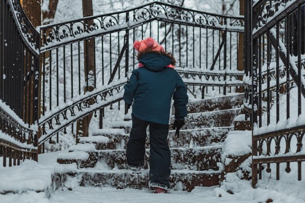 Kid on stairs in the snowy mountain park