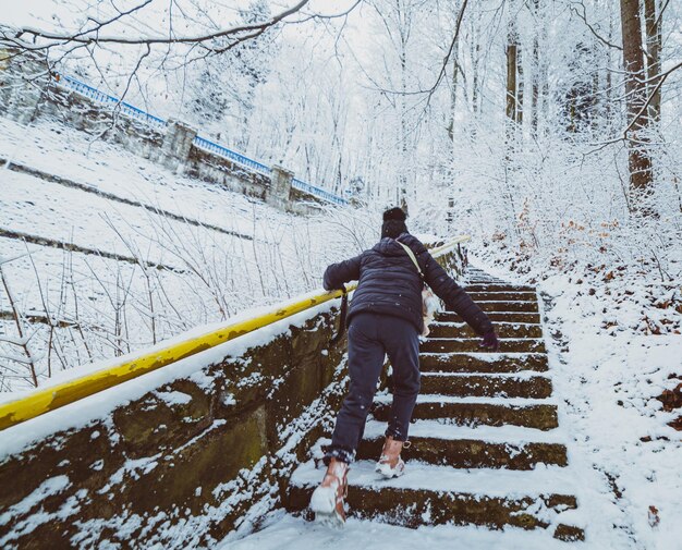 Kid on stairs in the snowy mountain park