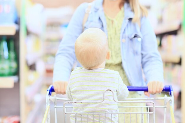 食料品のカートの店の子供は小さな顧客です