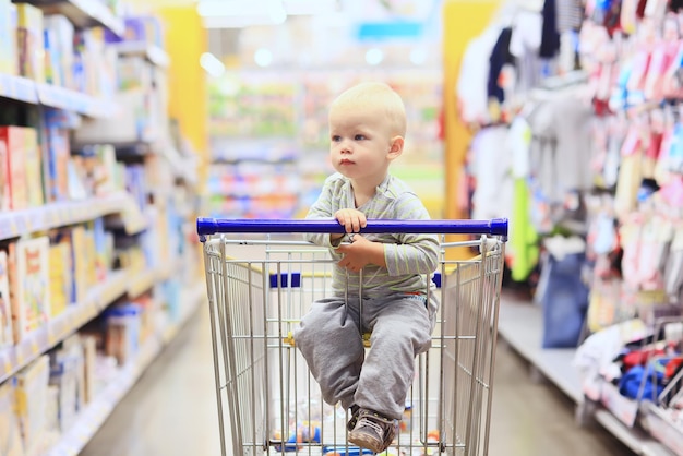 kid in the store on the grocery cart is a small customer