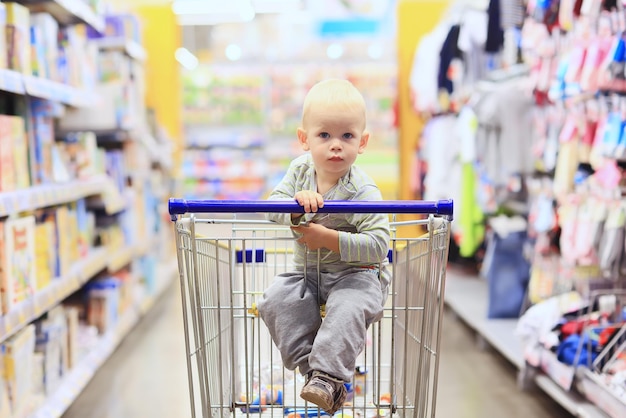 ребенок в магазине на продуктовой тележке-это маленький покупатель