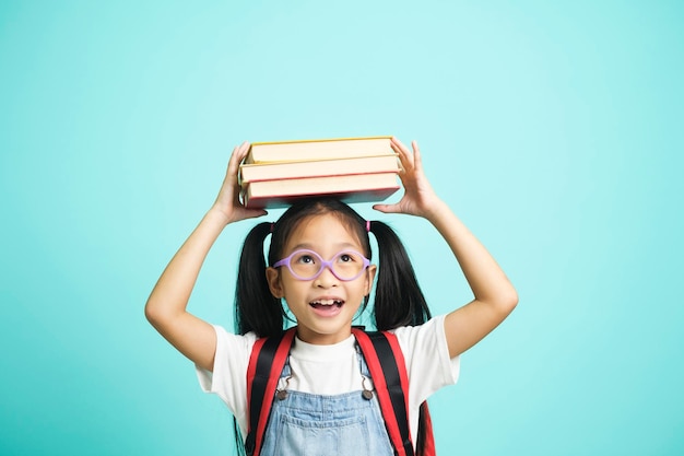 Kid students going to school girl funny smiling kid students girl with glasses hold books on her head