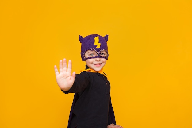 Kid in superhero posing on orange