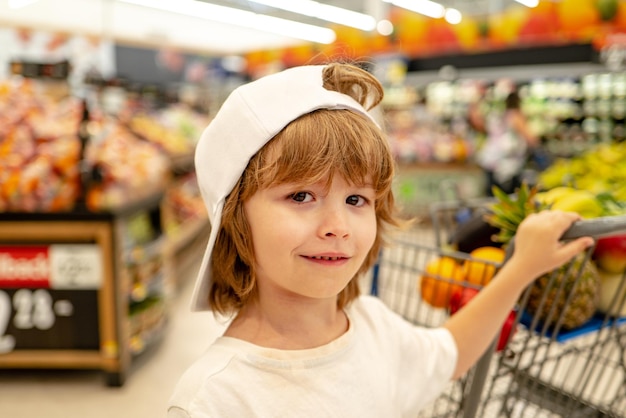 Kid in supermarket shop toddler boy with shopping bag in store