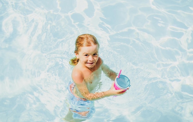 プールの子供たちの夏休み夏のアトラクションコンセプトスイミングプールで泳ぐ子供