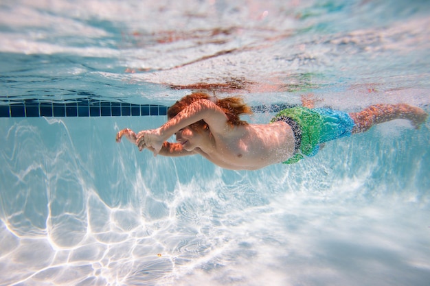 Kid swimming in pool underwater child boy swim under water in sea