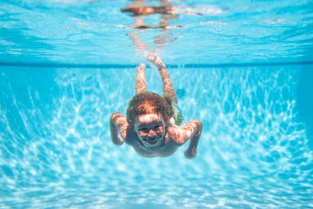 夏の海のビーチで水中を泳いでいる子供 青い海の水 海で泳いでいる子供の少年