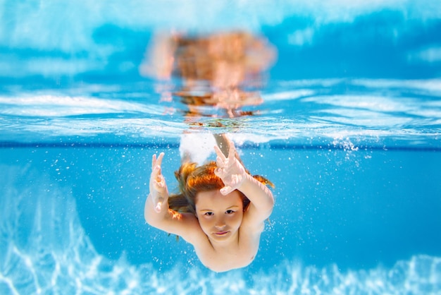 Kid swimming underwater on the beach on sea in summer Blue ocean water Child boy swimming in sea