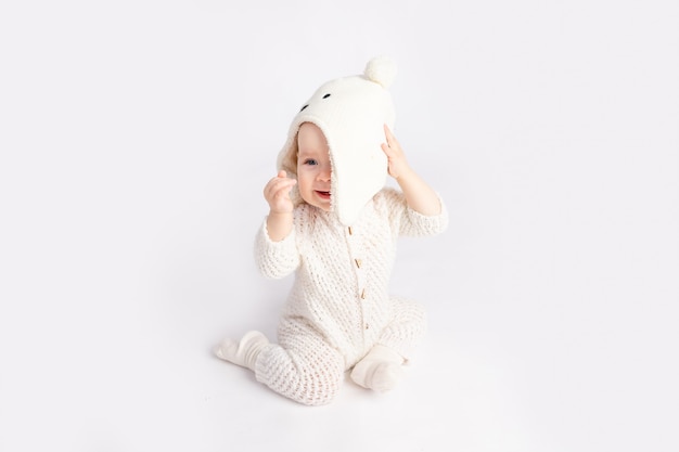 The kid takes off the hat on a white isolated background, space for text