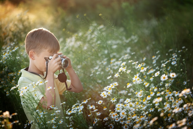 子供はカモミールフィールドで写真を撮る