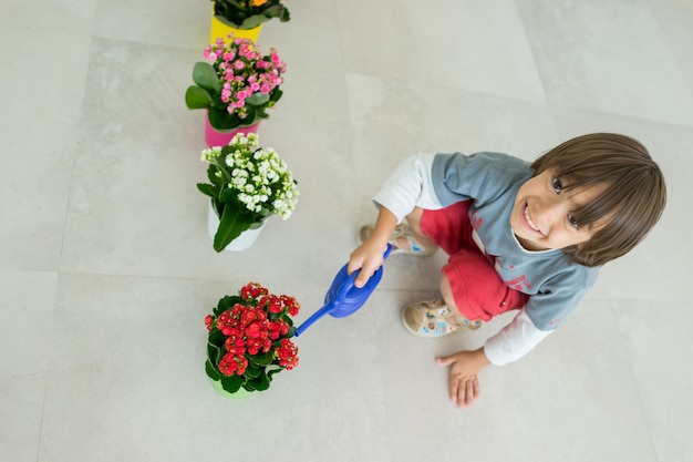 家庭で花や花を世話する子供