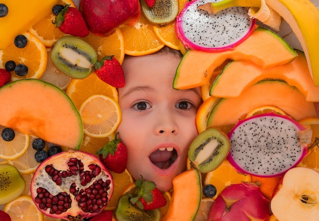 Kid tasting fruits funny fruits surprised kids face with mix of strawberry blueberry strawberry kiwi