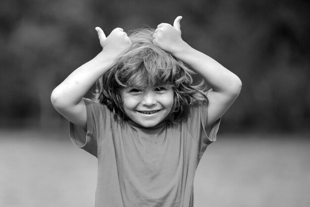 Kid thumbsup kind jongen keurt portret van lachende kleine jongen duimen opdagen