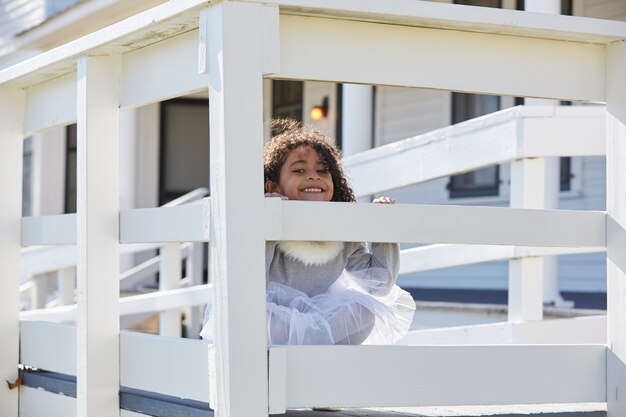 kid toddler girl playing hiding behind a fence