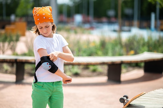 Kid trekt de beschermende uitrusting aan voordat hij gaat skateboarden