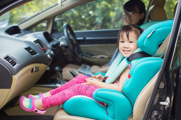 Photo kid wait for mother and sit in the car seat for safety before go to school.