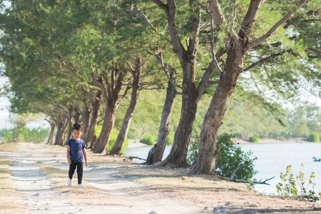 Kid walking alone between trees