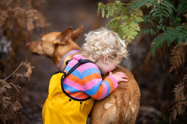 kid walking her dog on a lead on a path on a hike in germany