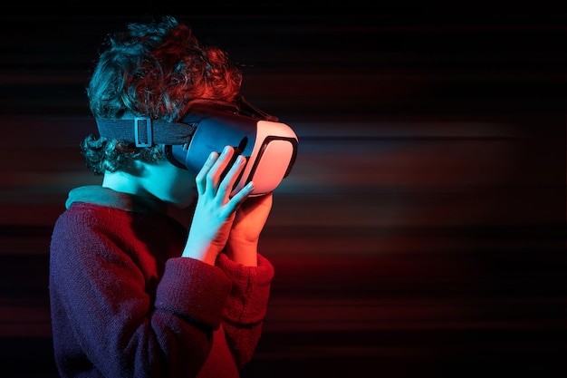 Kid wearing VR connected to metaverse. Innovative boy wearing VR headset playing online.