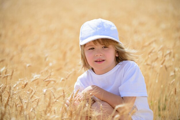 Kid in wheat field in summer outdoors