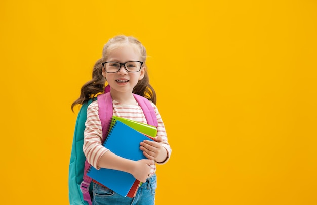 Kid with backpack on color background