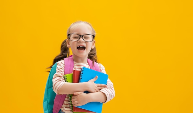 Kid with backpack on color background