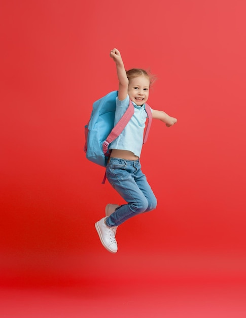 Kid with backpack on color background