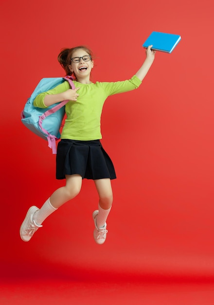 Kid with backpack on color background