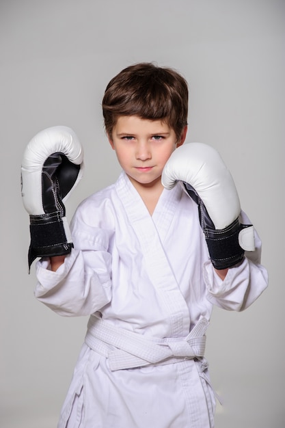 Kid with boxing gloves poses in studio