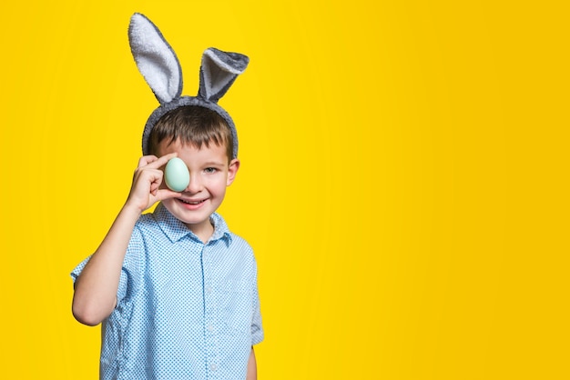 Un bambino con l'uovo di pasqua sul giallo