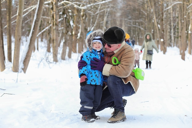 Il bambino con la famiglia si diverte in un parco invernale