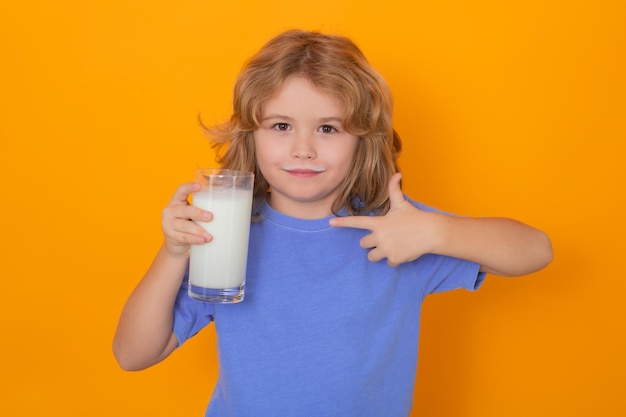 Kid with glass of milk isolated on yellow studio background