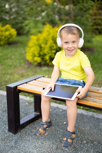 A kid with headphones and a tablet learns remotely