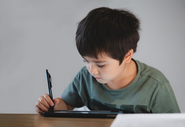 Kid zelfisolatie met behulp van tablet voor zijn huiswerk