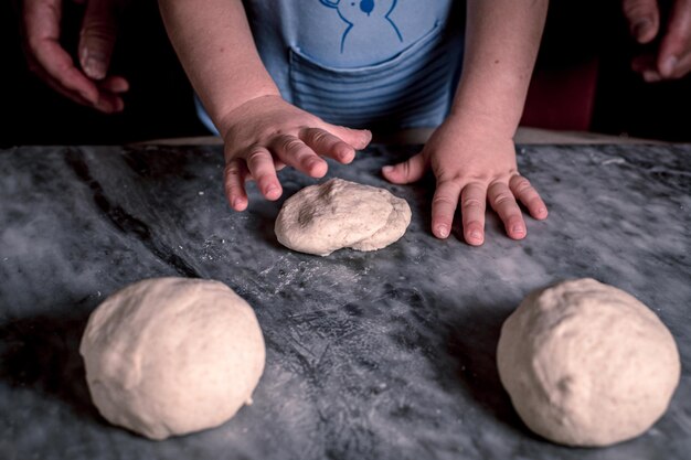 Kid39s handen deeg voor pizza op de marmeren tafel