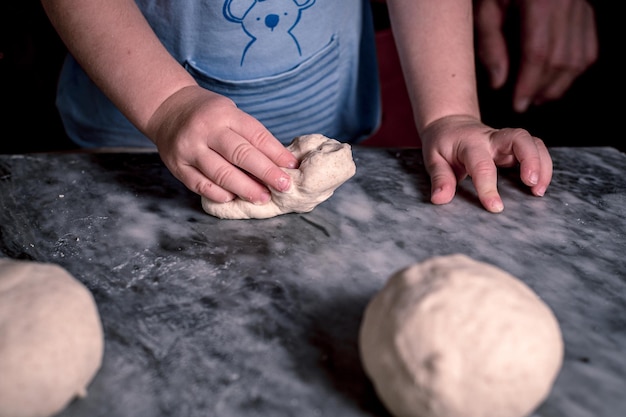 Kid39s hands dough for pizza on the marble table