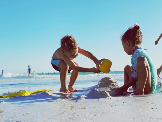 Foto i bambini stanno giocando sulla spiaggia.