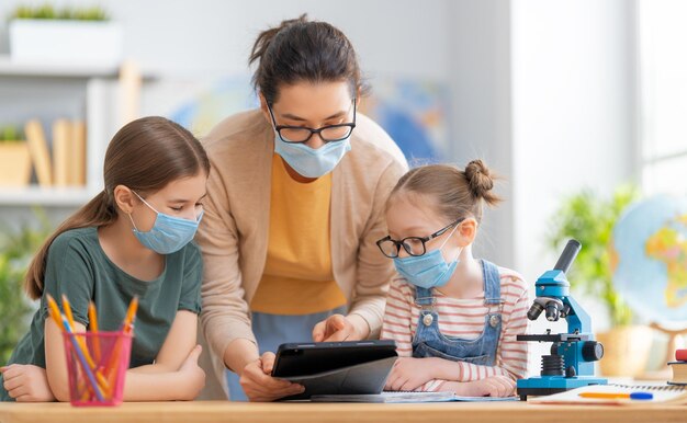 Kids are wearing facemasks learning in class