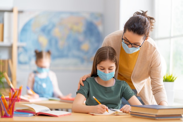 I bambini indossano maschere per imparare in classe