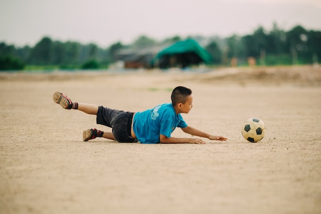 サッカーのサッカーをするゴールキーパーとしての子供たち