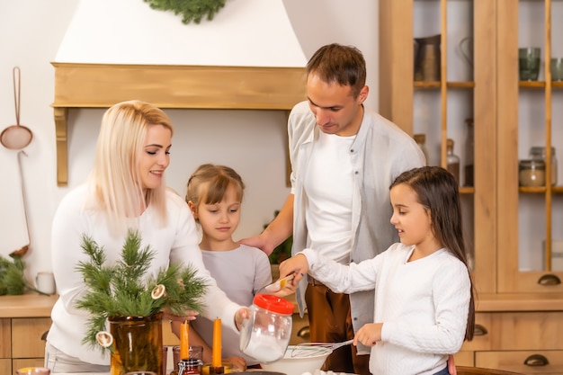 クリスマスのお祝いの前にクリスマスクッキーを焼く子供たち。家族