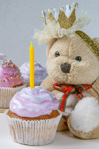 Photo kids birthday cupcake with teddy bear and sugar sprinkles