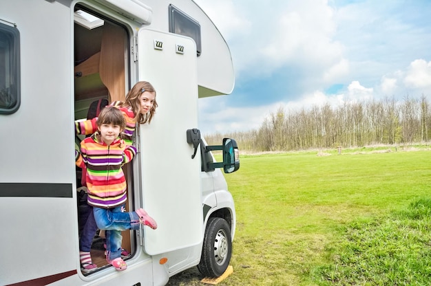 kids in camper rv have fun family travel in motorhome on holiday vacation trip in camping