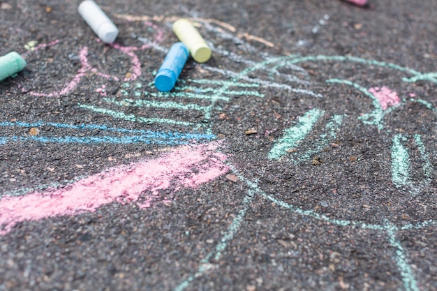 Photo kids chalk art on black pavement.