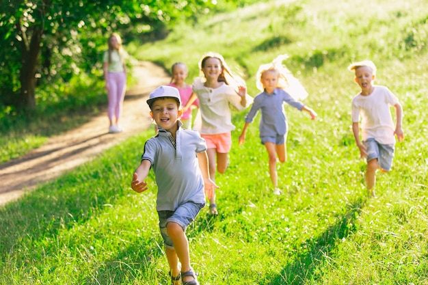 Kids, children running on meadow