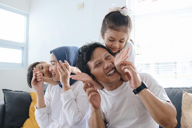 Photo kids closing eyes of parents using hands giving surprise family bonding at home playing hide and s