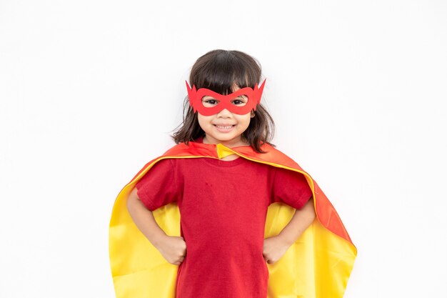 Концепция детей, улыбающаяся девочка, играющая супергероя на белом фоне