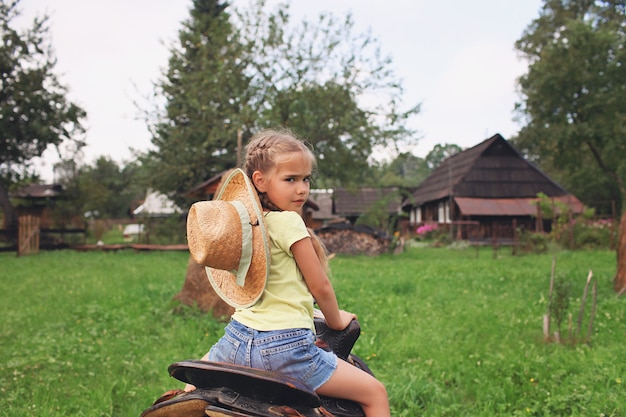 Kids in cowboy hats playing in western in the farm