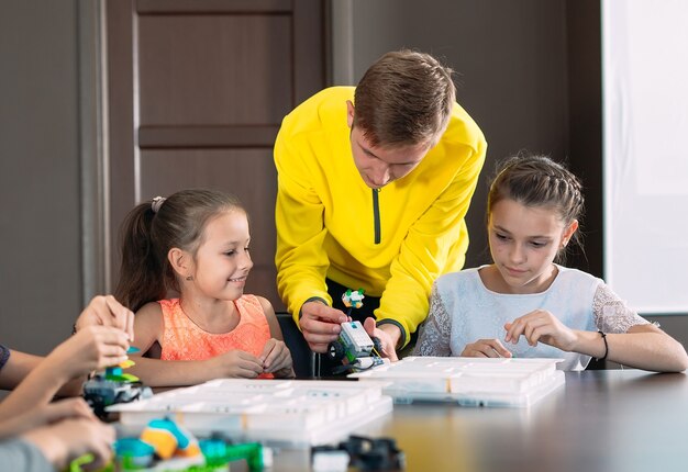 先生と一緒にロボットを作る子供たち。